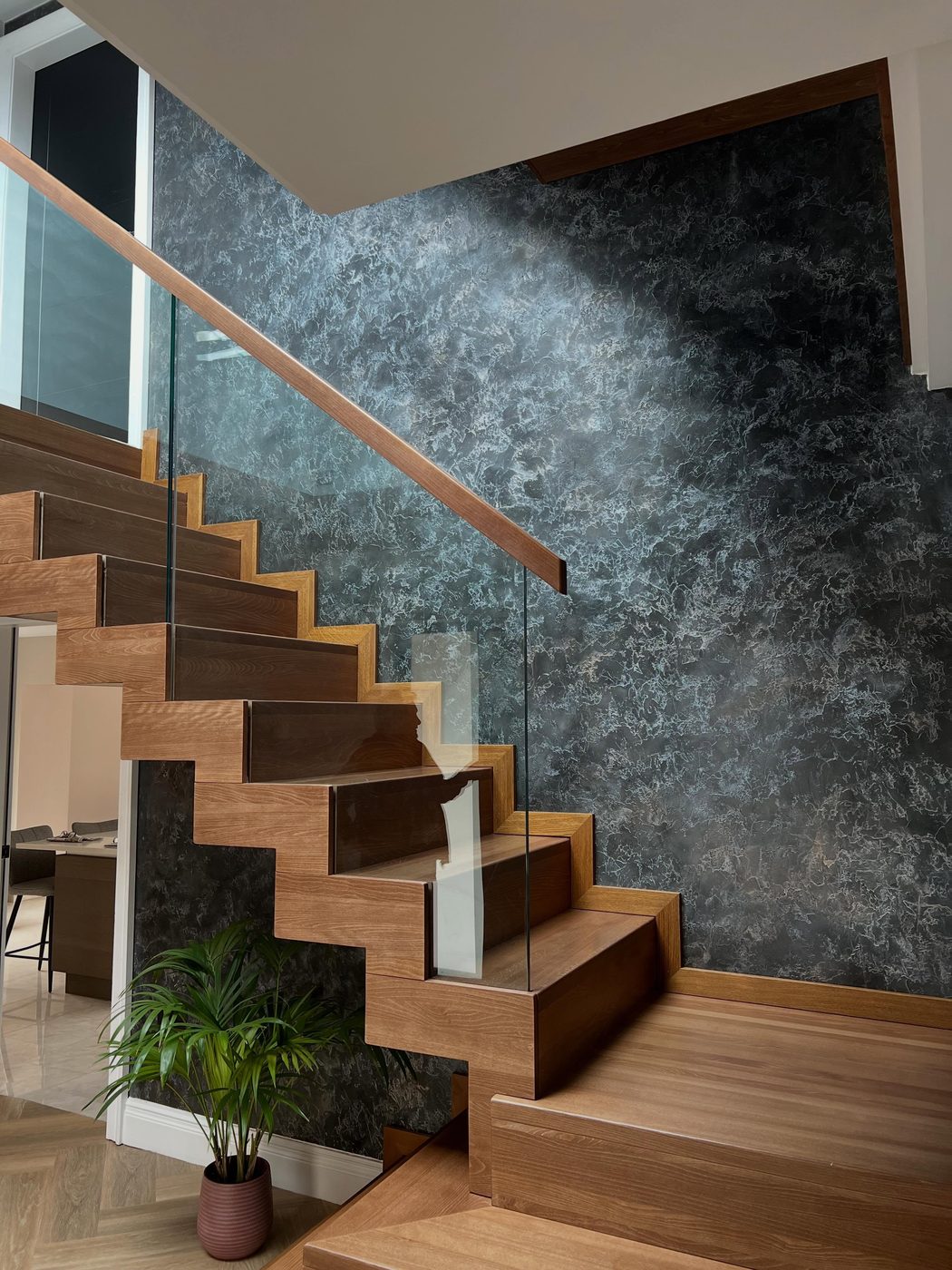 Marbled wall behind a floating oak stair